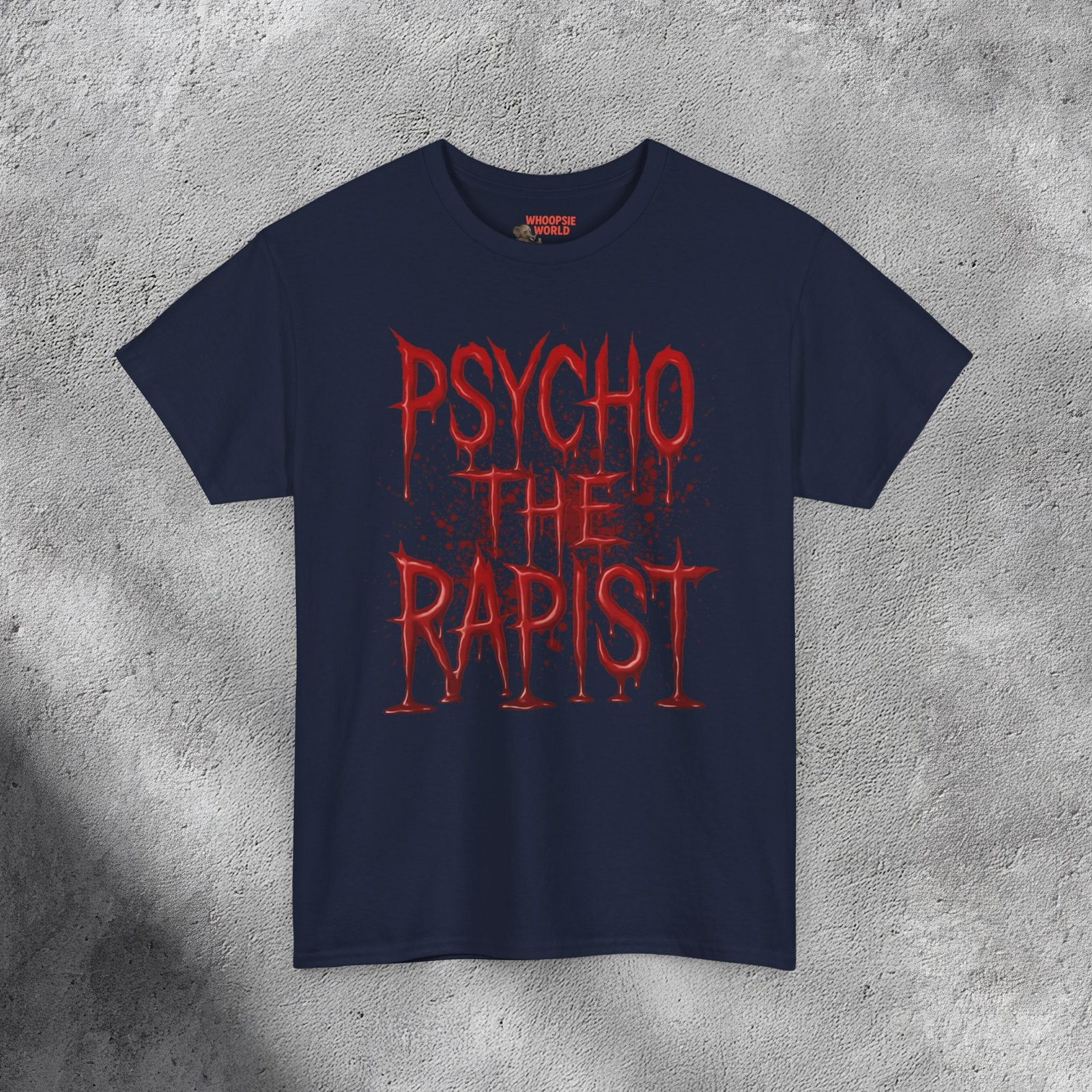 The T-shirt features bold, dripping red text reading “PSYCHO THE RAPIST” stacked in three lines against a dark black background. The letters appear glossy and wet, resembling fresh blood or thick paint, with realistic reflections and shadows adding depth. Behind the text, subtle red splatters and stains spread outward, enhancing the disturbing, horror-inspired aesthetic. The shirt’s fabric texture shows faintly beneath the design, making it feel gritty and raw — like a heavy metal or dark-humor statement piece with a shocking visual punch.
