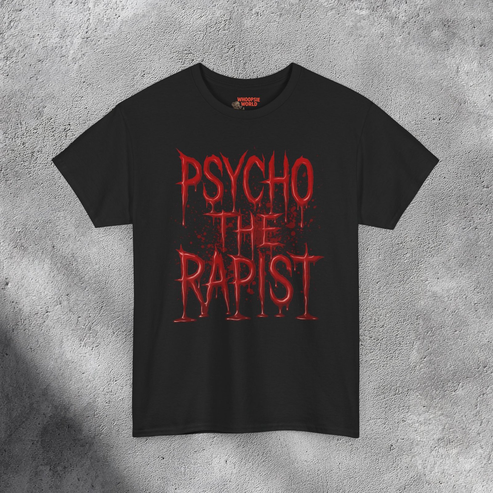 The T-shirt features bold, dripping red text reading “PSYCHO THE RAPIST” stacked in three lines against a dark black background. The letters appear glossy and wet, resembling fresh blood or thick paint, with realistic reflections and shadows adding depth. Behind the text, subtle red splatters and stains spread outward, enhancing the disturbing, horror-inspired aesthetic. The shirt’s fabric texture shows faintly beneath the design, making it feel gritty and raw — like a heavy metal or dark-humor statement piece with a shocking visual punch.
